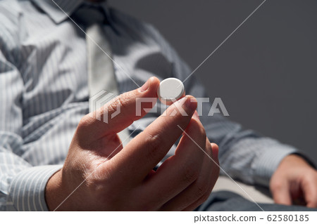 businessman with a pill, hands close view - businessman with a pill, hands close view - 62580185