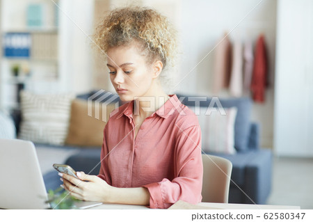 Woman using her phone Woman using her phone 62580347