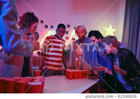 People playing beer pong at party 62580826