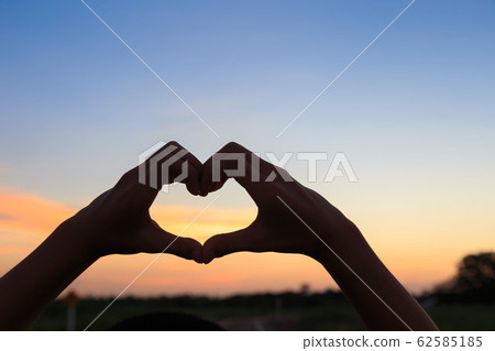 Female hands in the form of heart against sunlight Female hands in the form of heart against sunlight 62585185