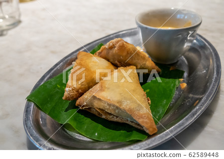 Samosa and sauce on tray 62589448