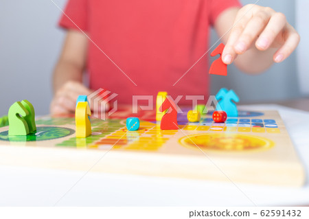 board game concept, kid hand play piece 62591432
