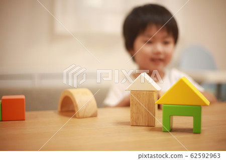 Boy playing with building blocks Boy playing with building blocks 62592963