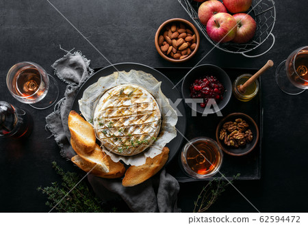 Baked brie served in a rustic manner with honey Baked brie served in a rustic manner with honey 62594472