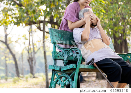 Insane asian woman would hurt her senior mother covering mouth,nose,daughter who is bored with caring for elderly patient by debilitating disease,physical abuse,violence,aggression,ungrateful concept 62595348