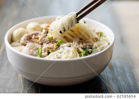 Rice noodles soup with pork and meat ball in a bowl eating by chopsticks 62595654