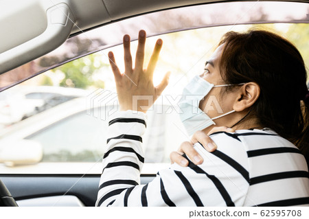 Depressed asian woman wearing medical face mask,thinking,needs breathe fresh air,sad female people about inhaling toxic air pollution,smog,dust,foul air in city began to affect her physical health  62595708