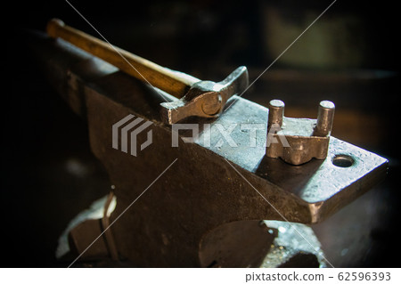 A hammer on the anvil in natural lighting indoors A hammer on the anvil in natural lighting indoors 62596393