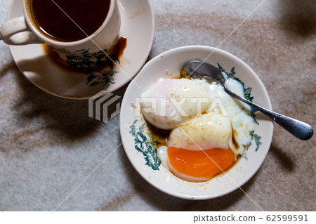 Half boiled eggs and coffee, popular and coffee.  Popular nutritious Chinese style breakfast in Malaysia kopitiam. Low key lighting. 62599591