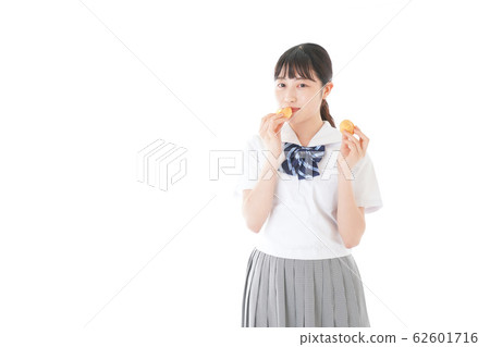 Female students in uniforms eating snacks 62601716