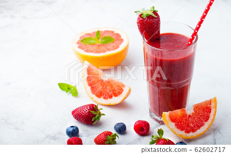 Strawberry, pink grapefruit smoothie with acai powder on a grey stone background. Copy space. 62602717