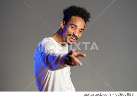 Young energetic african american man in white wear smiling and dancing in good mood on brown background. Young energetic african american man in white wear smiling and dancing in good mood on brown background. 62602928