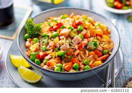 Asian fried rice with pork ham. Blue wooden background. Close up. Asian fried rice with pork ham. Blue wooden background. Close up. 62603118