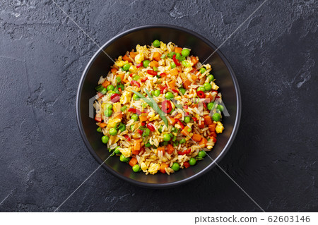 Asian fried rice with egg and vegetables. Dark stone background. Top view. 62603146