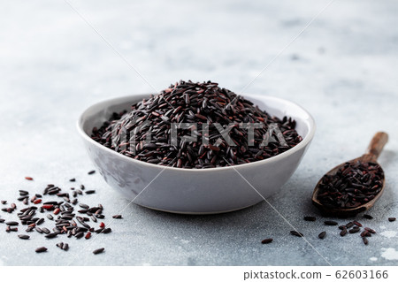 Black wild rice in a bowl. Grey stone background. Close up. 62603166