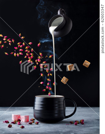 Rose flower tea with milk, flying ingredients. Black background. Rose flower tea with milk, flying ingredients. Black background. 62603347
