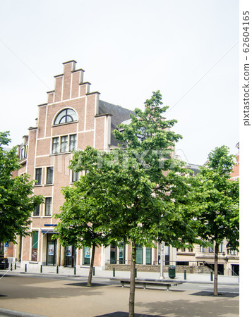 A red brick staircase-style Brussels building beside a tree-lined square A red brick staircase-style Brussels building beside a tree-lined square 62604165