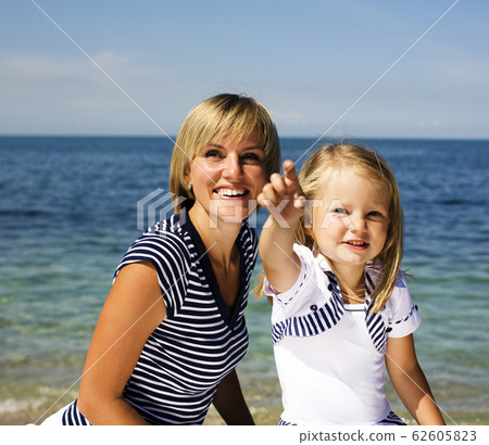 mother with daughter at sea cost together, happy real family smiling looking to horizont, lifestyle people concept, on vacations close up mother with daughter at sea cost together, happy real family smiling looking to horizont, lifestyle people concept, on vacations close up 62605823