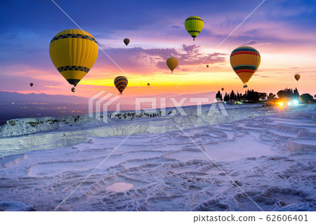 Hot air balloons and Natural travertine pools at sunset in Pamukkale, Turkey. Hot air balloons and Natural travertine pools at sunset in Pamukkale, Turkey. 62606401