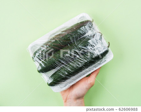Fresh produce wrapped in plastic film. 62606988