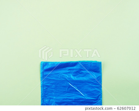 Blue plastic garbage bag roll on green background Blue plastic garbage bag roll on green background 62607012