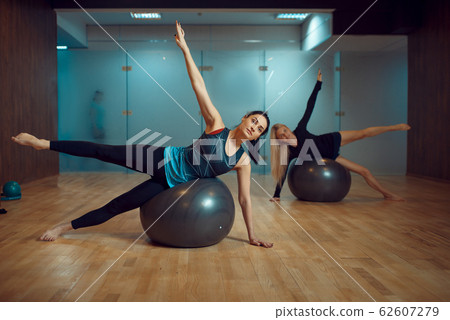 Two girls, pilates training with balls in gym Two girls, pilates training with balls in gym 62607279
