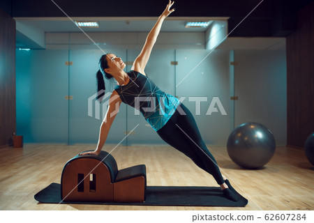 Slim girl on pilates training in gym, flexibility 62607284