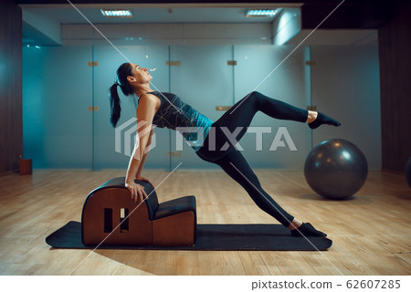 Slim girl on pilates training in gym, flexibility 62607285