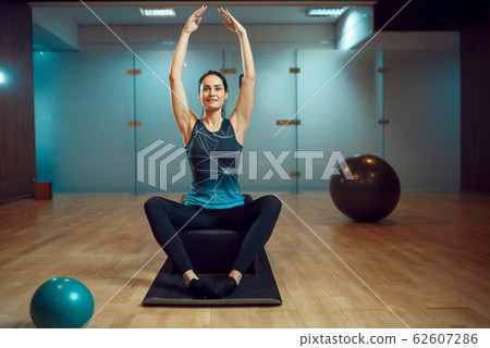 Slim woman in yoga pose on pilates training 62607286