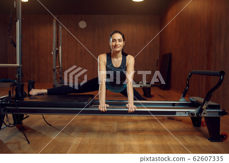 Slim girl doing the splits, pilates training 62607335
