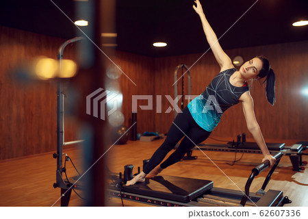 Slim girl, pilates training on exercise machine 62607336