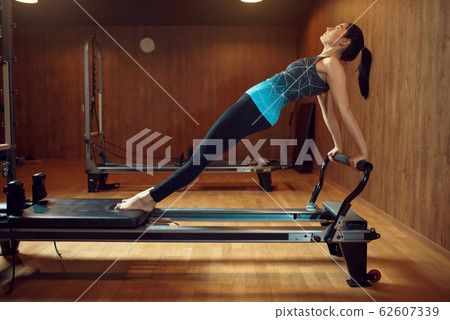 Fit woman, pilates training on exercise machine Fit woman, pilates training on exercise machine 62607339