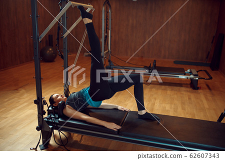 Slim woman doing stretching pilates exercise Slim woman doing stretching pilates exercise 62607343