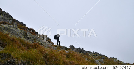Side view of man photographer in foggy mountains Side view of man photographer in foggy mountains 62607447