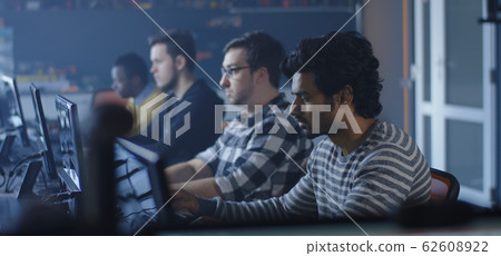Programmers working and one turning to the camera 62608922