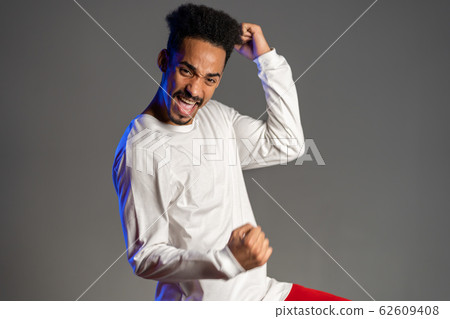 Portrait of happy excited african man in white showing YES sign gesture. 62609408
