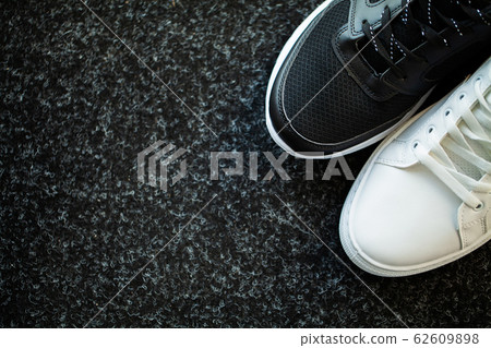 Pair of new stylish sneakers on floor at home. Pair of new stylish sneakers on floor at home. 62609898