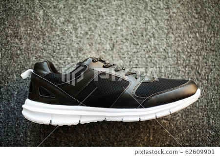 Pair of new stylish sneakers on floor at home. 62609901