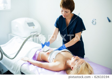 Skin care. Woman is in the process at the clinic lipomassage. 62610194