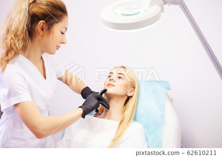 Lip Augmentation In Cosmetology Clinic. Beautiful Woman Getting Beauty Injection For Lips. 62610211