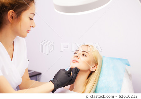 Lip Augmentation In Cosmetology Clinic. Beautiful Woman Getting Beauty Injection For Lips. 62610212