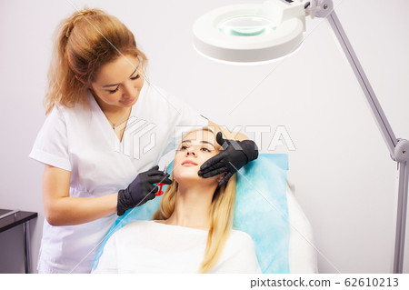 Lip Augmentation In Cosmetology Clinic. Beautiful Woman Getting Beauty Injection For Lips. 62610213