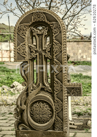Stone cross carved with ornaments in the form of the fourth letter of the Armenian alphabet, created by Mesrop Mashtots in the village of Oshakan Stone cross carved with ornaments in the form of the fourth letter of the Armenian alphabet, created by Mesrop Mashtots in the village of Oshakan 62610278