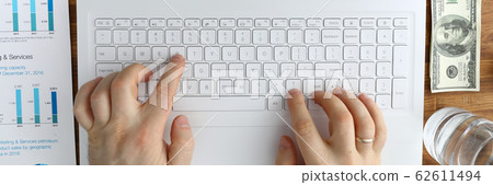 Male hands typing remote text on laptop keyboard Male hands typing remote text on laptop keyboard 62611494