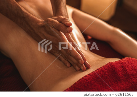 Alternative Medicine. Therapist healing woman doing abhyanga back massage with herbal oil hands on spine close-up 62611563