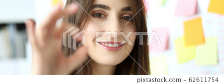 Cheerful female clerk showing all right symbol with her fingers 62611754