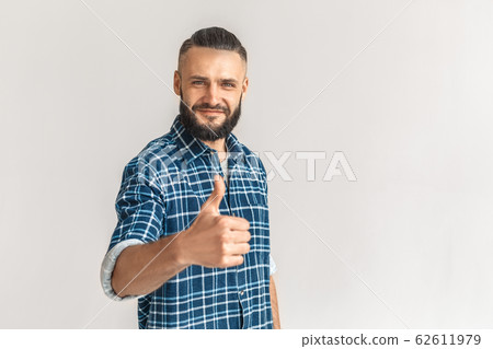 Freestyle. Guy in checkered shirt standing isolated on white showing thumb up smiling happy 62611979