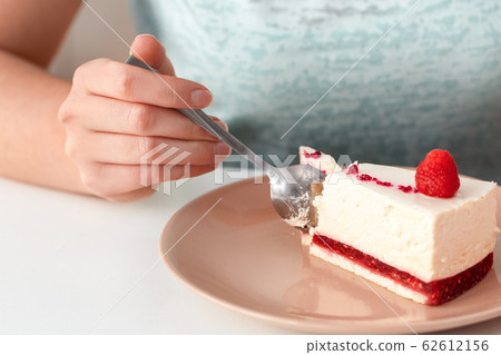 Break the Diet. Chubby girl sitting at kitchen table eating cake plate close-up Break the Diet. Chubby girl sitting at kitchen table eating cake plate close-up 62612156
