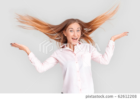 Freestyle. Young woman standing isolated on white throwing hair up playful Freestyle. Young woman standing isolated on white throwing hair up playful 62612208