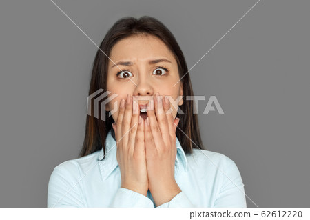 Freestyle. Young woman standing isolated on grey screaming frightened close-up Freestyle. Young woman standing isolated on grey screaming frightened close-up 62612220